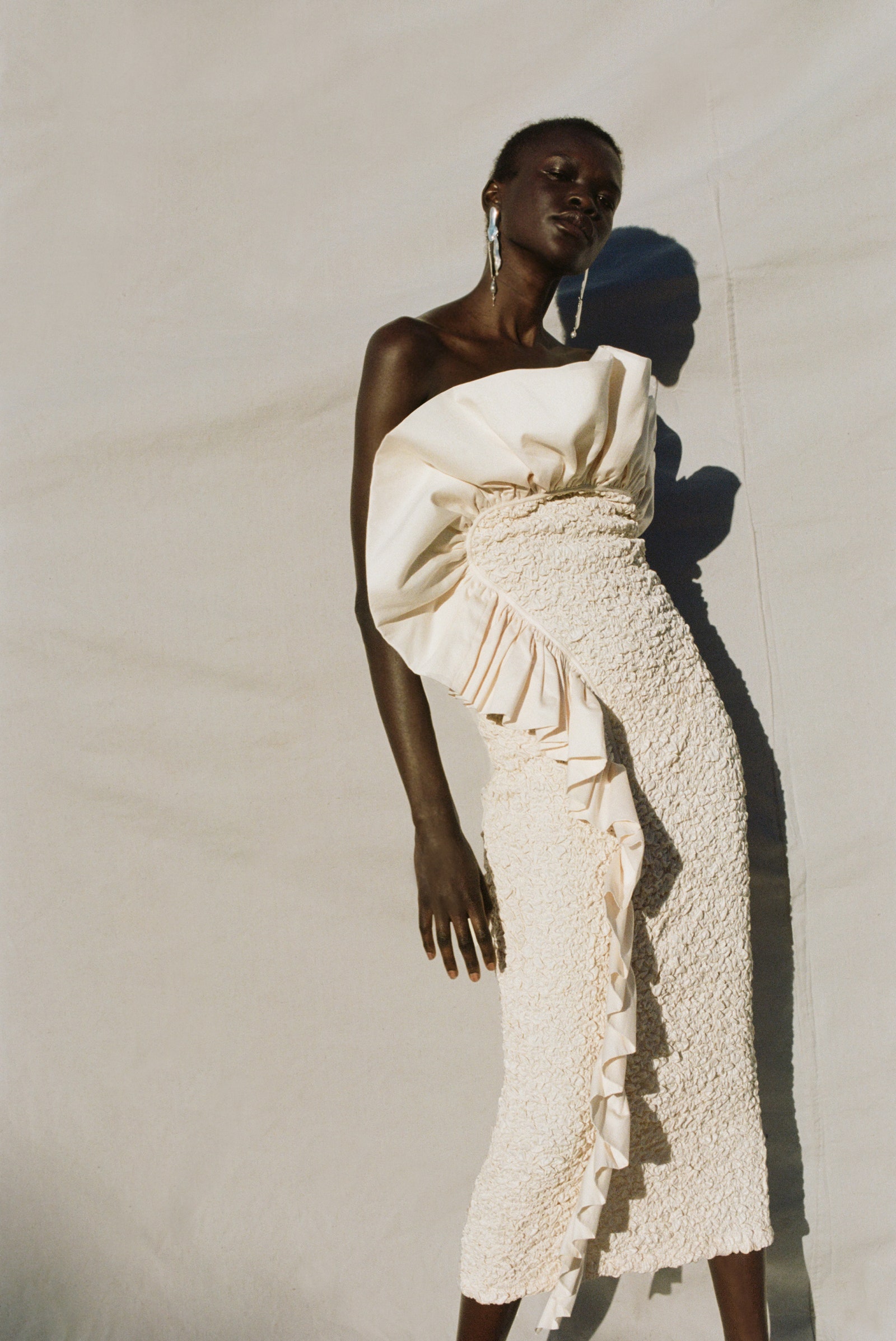 L'image peut contenir Aamito Lagum V&ecirc;tements Robe Personne adulte V&ecirc;tements de c&eacute;r&eacute;monie Accessoires Boucle d'oreille Bijoux et mariage